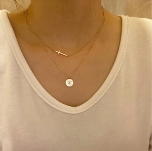Layered gold 925 silver necklace featuring a cross pendant and a round letter K charm