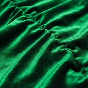 Macro detail van smaragdgroene fluwelen stof met elegant gerimpeld ontwerp en zachte glans