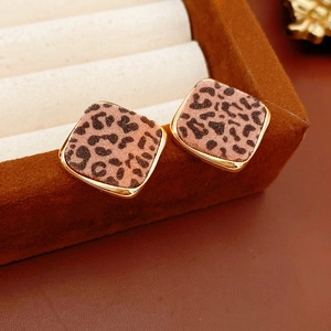 Gros plan de boucles d'oreilles losanges à motif léopard avec cadre doré sur velours