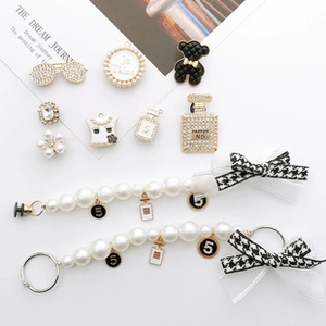 Detailed set of DIY shoe charms featuring pearl chains, metal bows and luxury perfume icons