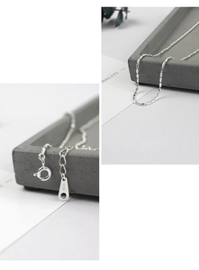 Detailed macro view of S925 sterling silver beaded chain necklace with clasp engraving