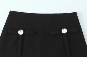 Detail der schwarzen gewebten Hose mit doppelter runder Strass-Schnalle an der Taille