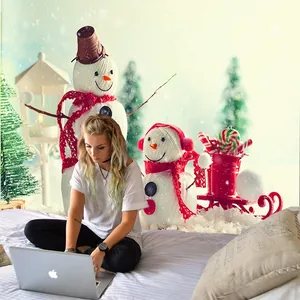 Detail view of a Christmas tapestry with snowman and tree patterns in a cozy bedroom