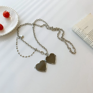 Silver vintage heart locket necklace with adjustable chain on a minimalist background