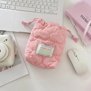 Detailed view of pink quilted drawstring camera bag with soft padding for protection
