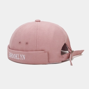 Detail of pink canvas brimless hat with white Brooklyn embroidery and adjustable metal buckle