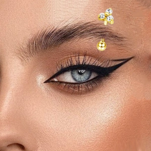 Close-up of a gold G23 titanium eyebrow ring with three sparkling white zircons