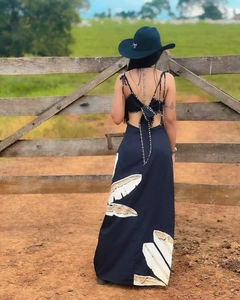 Detail of backless maxi dress with a tie-up bow and white feather print patterns