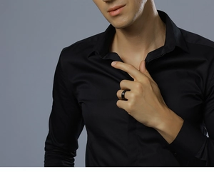 Detail of black tungsten ring with double grooves on male finger wearing a dress shirt