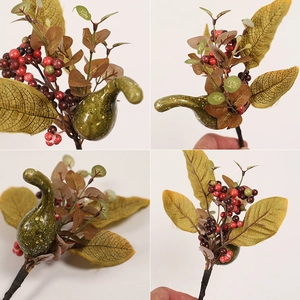 Detail of artificial sunflower and berry branches with green pear fruit and yellow leaves