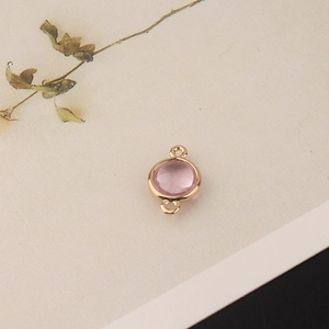 Close-up of light pink round crystal charm with gold plated double loop connectors