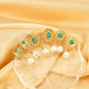 Bohemian gold plated earrings with turquoise and baroque pearls on silk background