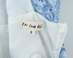 Detail of V-neck lace neckline and zipper on a blue floral porcelain print dress