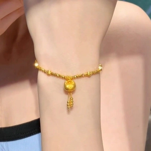 24k gold-plated lucky lock bracelet with tassel pendant on a model's wrist