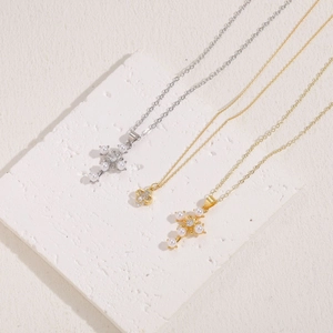 Gold and silver cross pearl pendant necklaces on a textured marble background