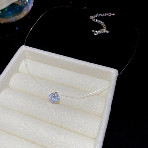 Dettaglio macro di un ciondolo in zircone tondo su una collana in una scatola per gioielli