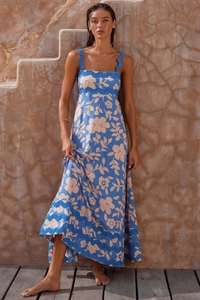 Detailed view of blue floral long dress featuring wide scalloped straps and a romantic style