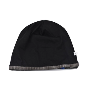 Detail view of knitted beanie showing grey striped hem and blue adjustable drawstring buckle