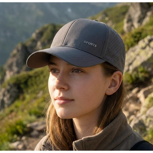 Detail of dark grey breathable mesh baseball cap with silver Sports lettering outdoors