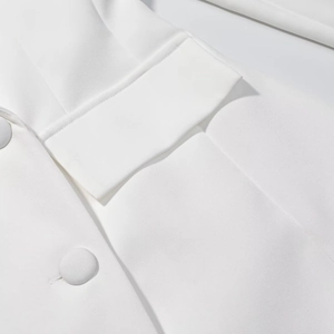 Detail view of a white blazer dress showing flap pocket and fabric covered button