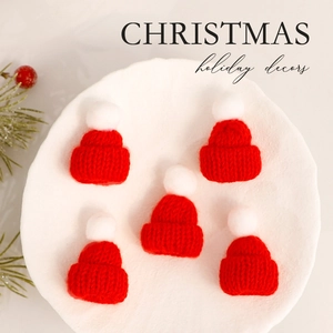 Mini red and white knitted Christmas hats set on white plate for DIY holiday decorations