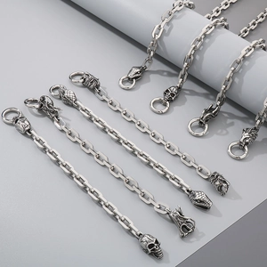 Detailed view of silver stainless steel chain links with animal head and skull charms