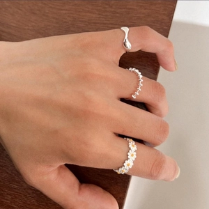 Detailed view of a 3-piece silver daisy ring set featuring floral and beaded designs