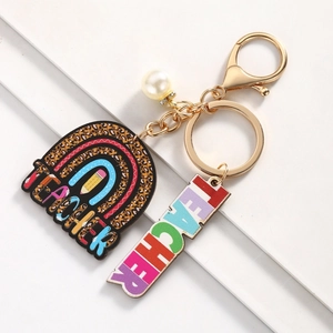 Detail of teacher keychain featuring rainbow charm, leopard print, and pearl pendant