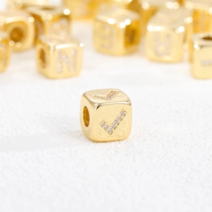 Macro shot of 18K gold plated cube bead with zircon inlay and checkmark pattern