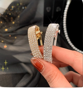 Macro shot of gold and silver curved ponytail clips with high-shine rhinestones