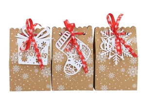 Kraft paper Christmas gift bags with red ribbons and festive laser-cut card pendants