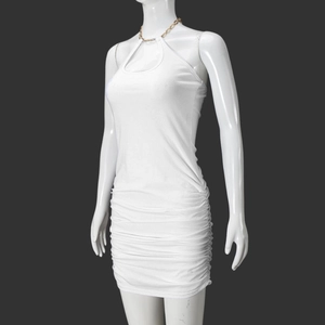 Détail de la robe moulante blanche avec licou en chaîne dorée et texture froncée du tissu