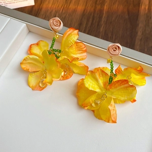 Detail of yellow fabric floral earrings with pink rose beads and teardrop pendants