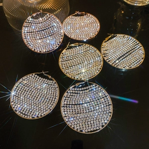 Macro shot of oversized silver hoop earrings with sparkling crystal pavé stones