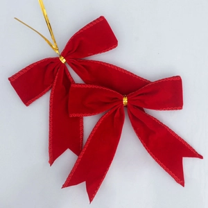 Détail de nœuds en velours rouge avec attaches dorées pour décoration de cadeaux