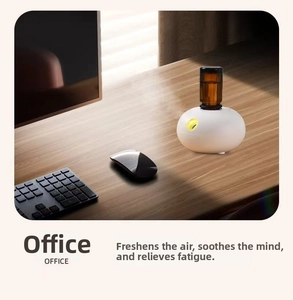Waterless aromatherapy diffuser with brown essential oil bottle on an office desk