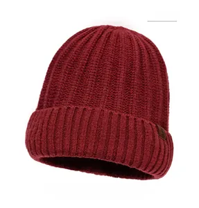 Close-up of ribbed dark red knit beanie with vintage brown leather side patch detail