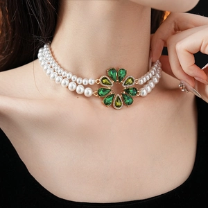 Primo piano della collana di perle a doppio strato con pendente a fiore in gemma verde