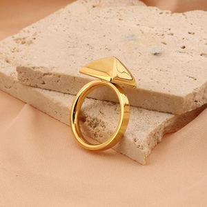 Dettaglio dell'anello in acciaio al titanio placcato oro 18k con design geometrico a piramide