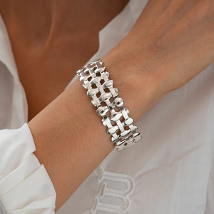 Detail of silver architectural hollow mesh cuff bracelet with mirror-like finish