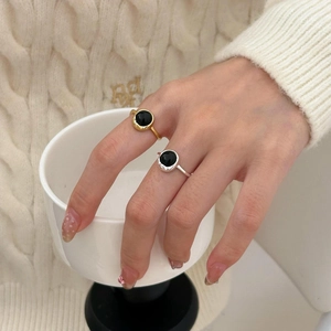Close-up of minimalist S925 silver rings with black agate stones worn on hand