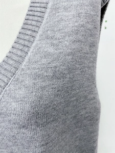 Detailed view of gray V-neck knitted vest showing fine ribbed collar and wool texture
