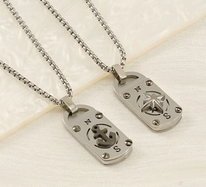 Détail des pendentifs boussole et ancre sur des chaînes vénitiennes en argent et noir mat