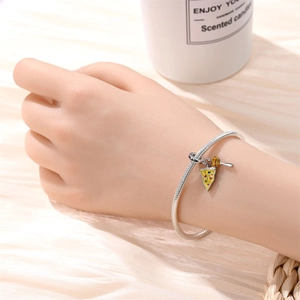 Silver snake chain bracelet with colorful pizza and cutlery charms on a wrist