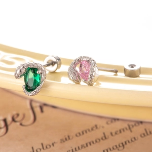 Oval zircon snake earrings in green and pink on vintage paper and ceramic display