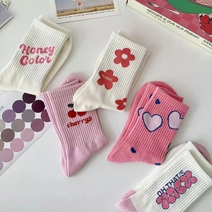 Dettaglio di cinque paia di calzini in cotone con motivi di cuori rosa e ciliegie dolci