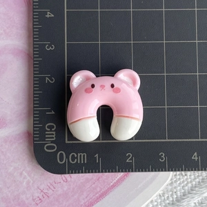 Macro detail of a 2cm resin bear charm showing precise measurements on a black cutting mat