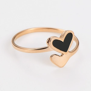 Dettaglio dell'anello a doppio cuore in oro rosa con smalto nero e finitura lucida