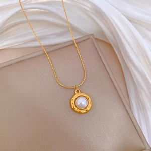 Close-up of a titanium steel gold necklace with a round pearl pendant on white silk