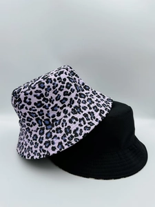 Detail view of leopard print and solid black reversible cotton bucket hats for sun protection